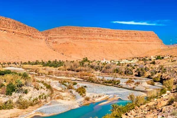 Coloridas montañas y río en Marruecos, destino turístico ideal para turismo de aventura y naturaleza.